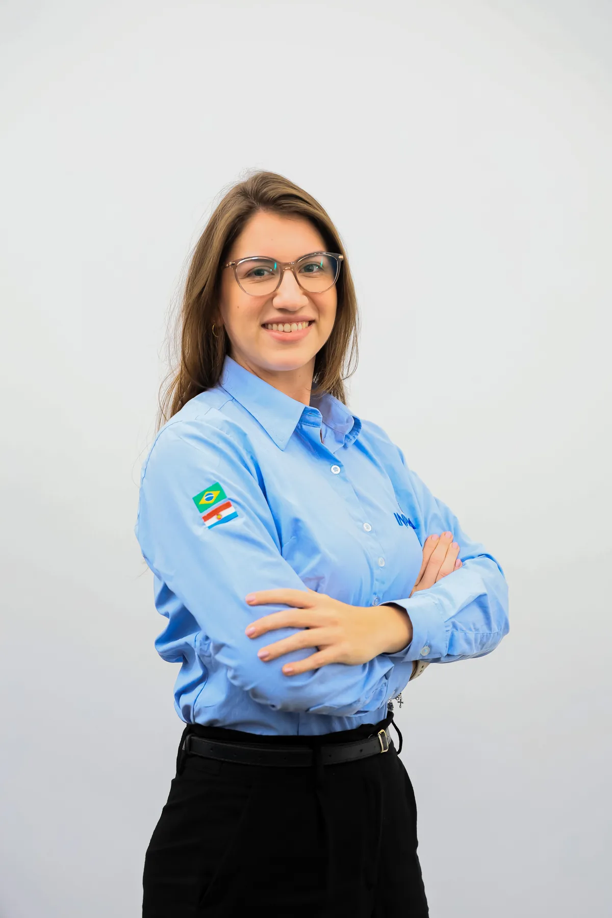 Funcionária da Inpasa de braços cruzados, com o uniforme da empresa